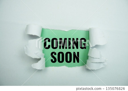 Coming soon message written on green paper with torn paper background Coming soon message written on green paper with torn paper background 135076826