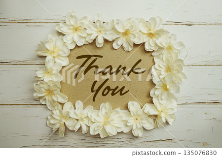 Thank You text written on paper card with flower decoration on wooden background 135076830