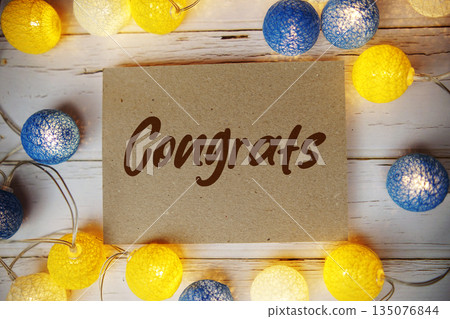 Congrats text with LED cotton balls decorate on wooden background 135076844