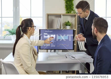 Colleagues discussing analytics and finance data on screen during strategy meeting Colleagues discussing analytics and finance data on screen during strategy meeting 135076953