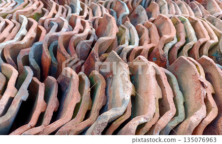 Rows of Stacked Traditional Terracotta Roof Tiles, Clay Construction Material Pattern Rows of Stacked Traditional Terracotta Roof Tiles, Clay Construction Material Pattern 135076963