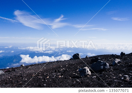 A vast sea of clouds and clear blue skies seen from the summit of Mount Fuji 135077071