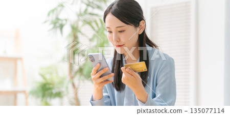 Woman holding a smartphone and a credit card (banner) Woman holding a smartphone and a credit card (banner) 135077114