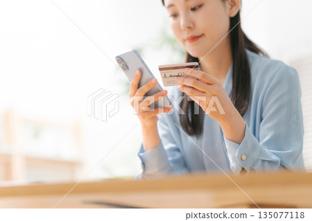 A woman with a smartphone and a credit card A woman with a smartphone and a credit card 135077118