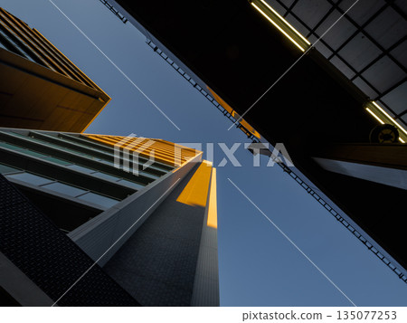 從下方拍攝的夕陽照耀下的高層公寓大樓的城市景觀。房地產。 從下方拍攝的夕陽照耀下的高層公寓大樓的城市景觀。房地產。 135077253