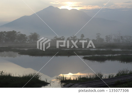 Silent Oze: A pond reflecting the mountain range and the rays of the morning sun Silent Oze: A pond reflecting the mountain range and the rays of the morning sun 135077306