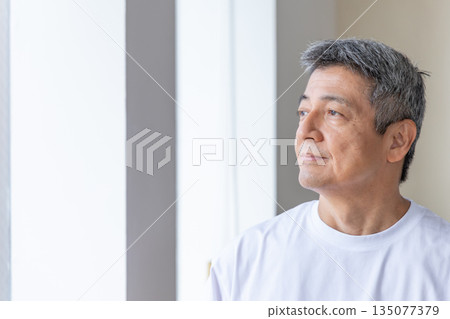 Senior man looking out the window Senior man looking out the window 135077379