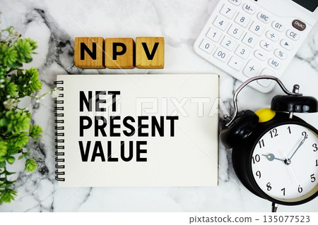 NPV Net Present Value text with calculator and alarm clock on marble background 135077523