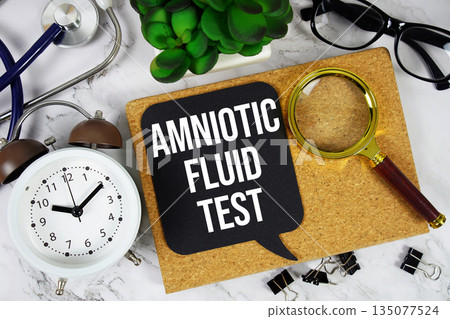 Amniotic Fluid Test text with alarm clock, calculator and stethoscope on marble background 135077524