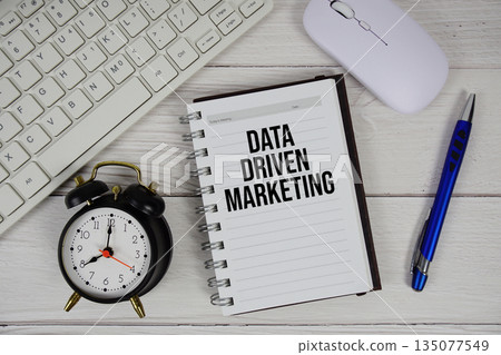Data Driven Marketing text with alarm clock, keyboard and wireless mouse on wooden background Data Driven Marketing text with alarm clock, keyboard and wireless mouse on wooden background 135077549