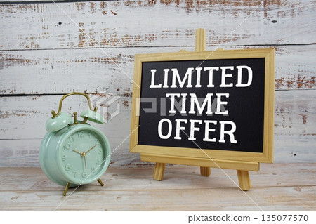 Limited Time Offer text written on blackboard with alarm clock on wooden background 135077570