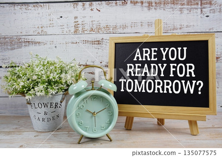 Are You Ready For Tomorrow? text written on blackboard with alarm clock on wooden background 135077575