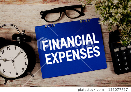 Financial Expenses text with alarm clock and calculator on wooden background Financial Expenses text with alarm clock and calculator on wooden background 135077737