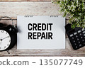 Credit Repair text with alarm clock and calculator on wooden background 135077749