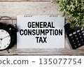 GCT General Consumption Tax text with alarm clock and calculator on wooden background 135077754