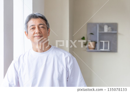 Senior men standing at the windowside 135078133