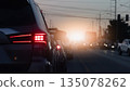 Rear side of car with red brake light on during traffic jam on the road at sunset. Rush hour transportation and driving safety concept. 135078262