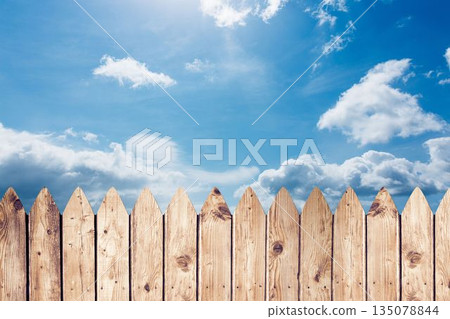 Wooden picket fence is stretching across flat design under bright blue sky with white clouds 135078844