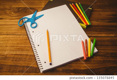 Spiral-bound notebook is lying on desk in flat design with pencil, scissors and colorful art tools Spiral-bound notebook is lying on desk in flat design with pencil, scissors and colorful art tools 135078845
