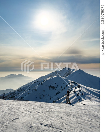 Sun over snowy mountain slope at Amirsoy ski resort. Winter landscape Sun over snowy mountain slope at Amirsoy ski resort. Winter landscape 135079075