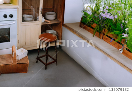 Cozy vintage kitchen corner with rustic wooden furniture, white stove, wicker basket, and lavender flowers. Perfect for cottagecore home decor and lifestyle interior design Cozy vintage kitchen corner with rustic wooden furniture, white stove, wicker basket, and lavender flowers. Perfect for cottagecore home decor and lifestyle interior design 135079182