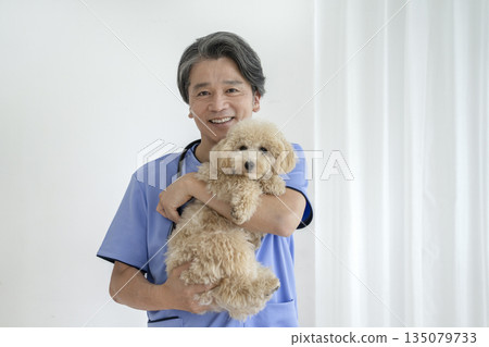笑容可掬的資深獸醫和比熊貴賓犬幼犬 135079733