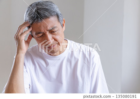 客廳裡，一位老人抱著頭 135080191