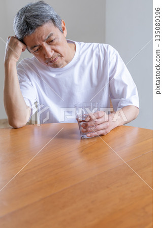 老人用手托著頭，雙手沾滿水 135080196