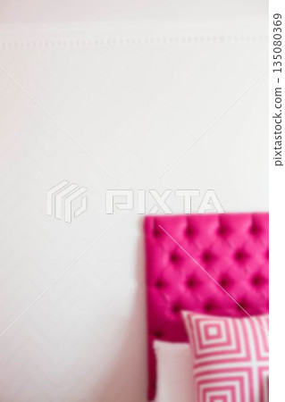 Pillow on pink bed against white wall 135080369