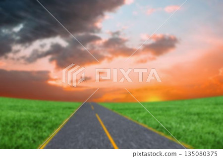 road by green grass during sunset 135080375