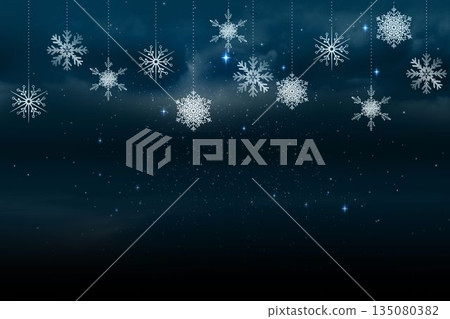 Snowflakes hanging against blue background Snowflakes hanging against blue background 135080382