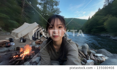 A woman making a bonfire at a campsite 135080408
