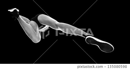 Female athlete running against black background Female athlete running against black background 135080598