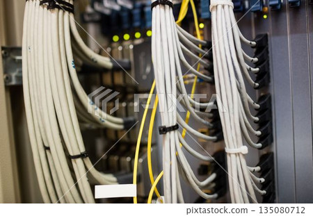 Flat design showing white and yellow cables bundling in brackets into patch panel with glowing LEDs 135080712