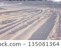 Tire tracks left on snowy roads. Gentle street lights shining on snowy roads late at night. 135081364