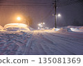 Tire tracks left on snowy roads. Gentle street lights shining on snowy roads late at night. 135081369