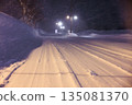 Tire tracks left on snowy roads. Gentle street lights shining on snowy roads late at night. 135081370
