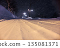 Tire tracks left on snowy roads. Gentle street lights shining on snowy roads late at night. 135081371