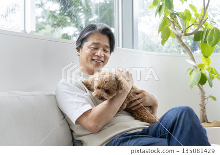 A middle-aged man holding his beloved dog. Image of life with a dog. 135081429