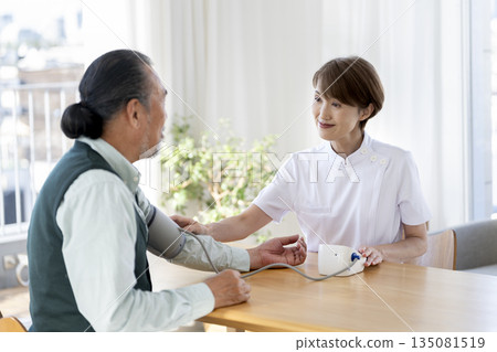 醫護人員為老人測量血壓 醫護人員為老人測量血壓 135081519