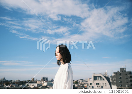 年輕女子站在屋頂上向外望去 135081601