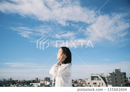 年輕女子站在屋頂上向外望去 135081604