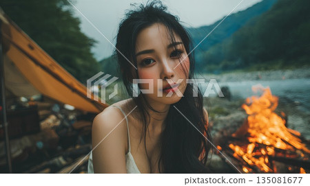 一位女士在湖邊享受篝火。 135081677