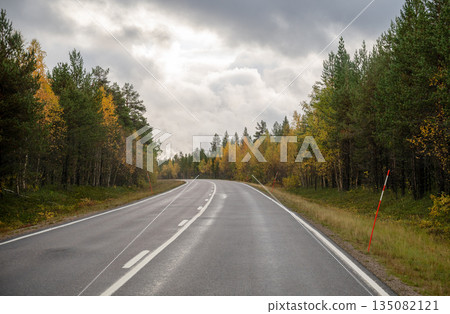 Empty autumn road through colorful forest in Finnish Lapland Empty autumn road through colorful forest in Finnish Lapland 135082121