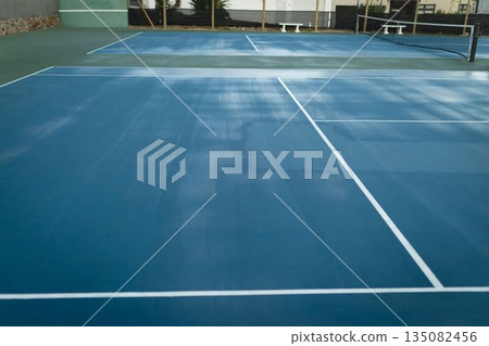 Flat design is showing empty blue hard tennis court with black net, chain-link fence, green wall 135082456