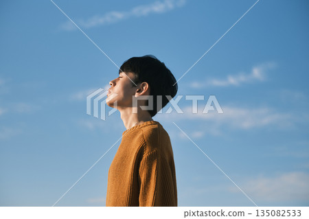 Portrait of a young man against a blue sky 135082533