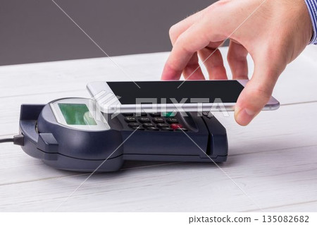 Man using smartphone to express pay Man using smartphone to express pay 135082682