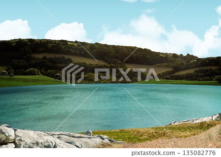 Calm turquoise lake is mirroring clouds, edging grassy bank, winding path, rolling hills Calm turquoise lake is mirroring clouds, edging grassy bank, winding path, rolling hills 135082776