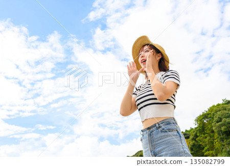 A woman in a straw hat shouts into the sky. (Photography courtesy of Oki Seaside Resort Miyabi) A woman in a straw hat shouts into the sky. (Photography courtesy of Oki Seaside Resort Miyabi) 135082799