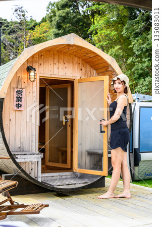 A barrel-shaped sauna and a smiling woman. (Photography provided by Oki Seaside Resort Miyabi) A barrel-shaped sauna and a smiling woman. (Photography provided by Oki Seaside Resort Miyabi) 135083011